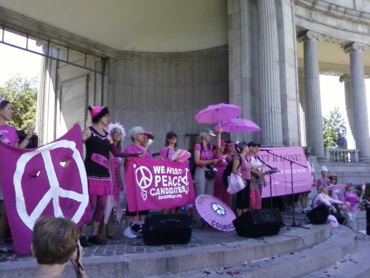 several people at a rally with pink signs