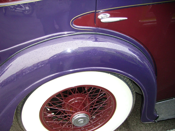 a red and purple car wheel is painted white