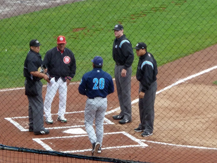 three men in baseball uniforms on a baseball field