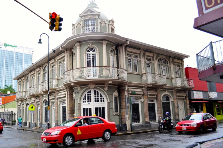 two red taxis parked outside a large building