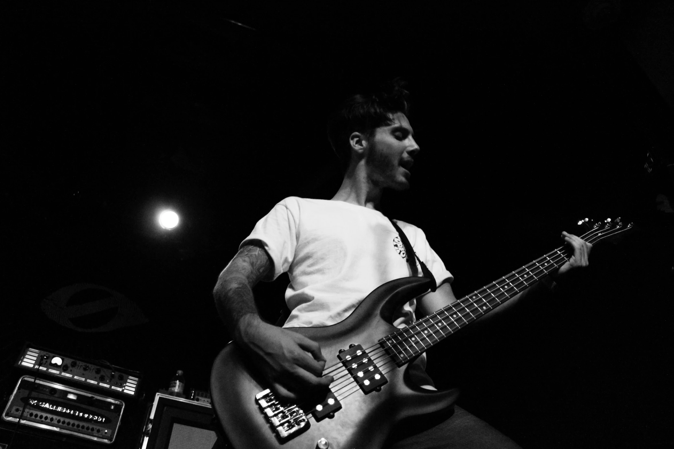 the man is playing on his guitar while standing in front of some sound equipment