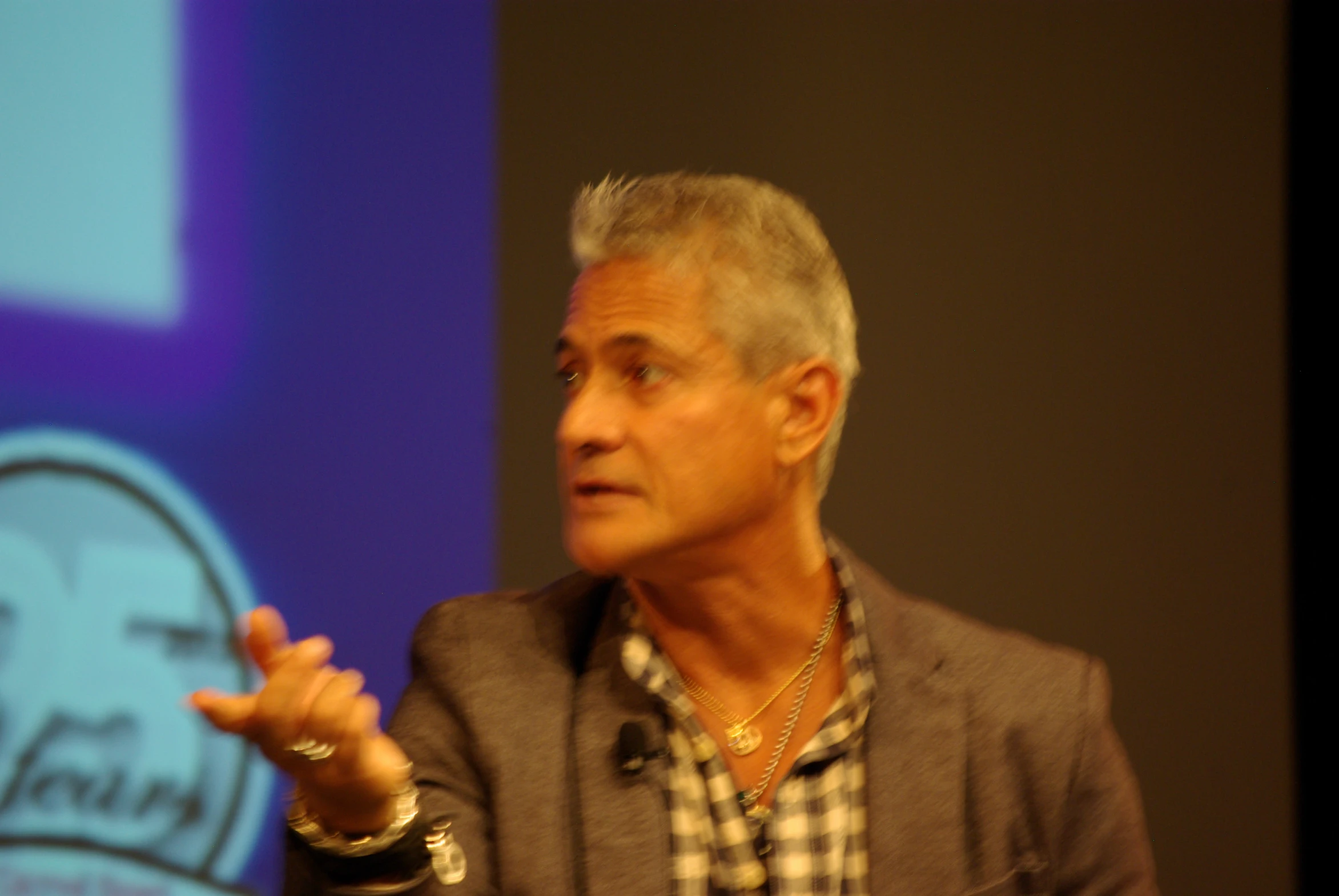 a man with a surprised look stands in front of a projection screen