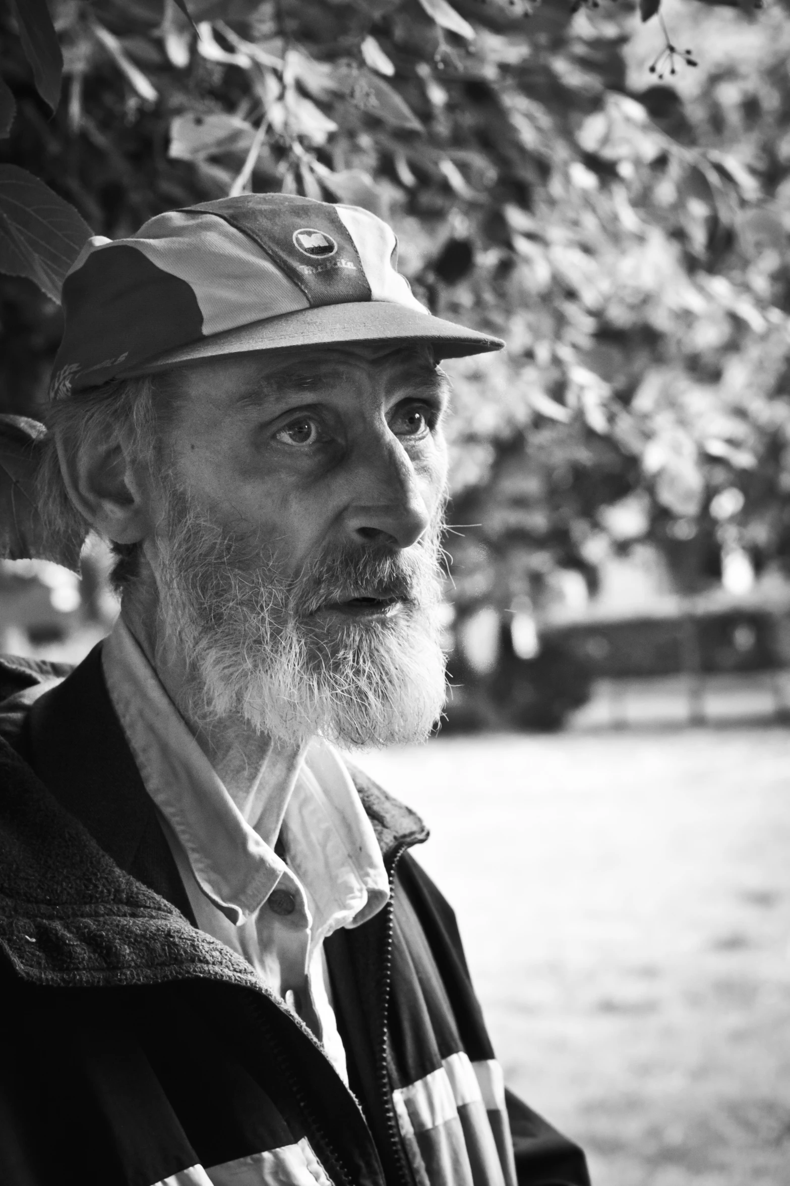 an old man standing in front of a tree