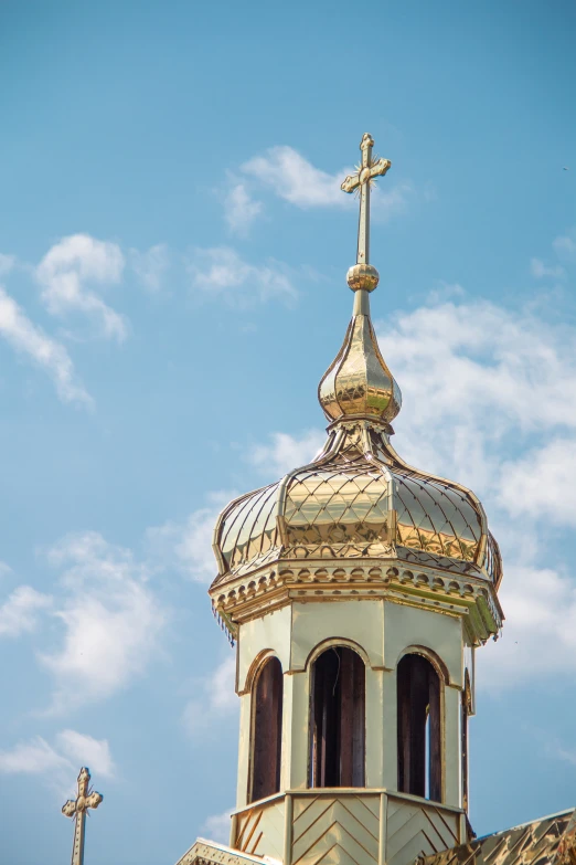 the roof top of a building has a cross and is very tall