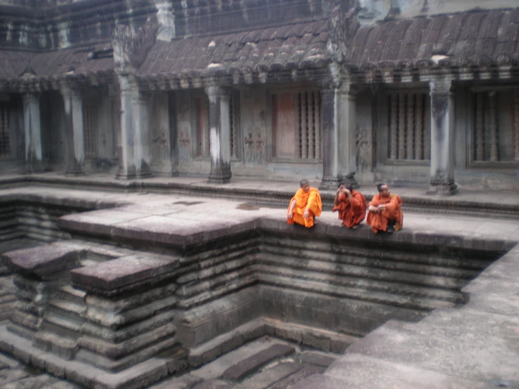 the monks are sitting on their steps in front of a wall