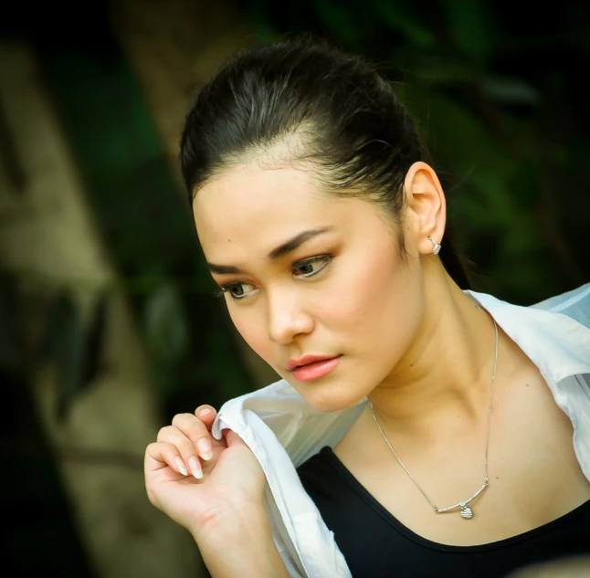 a woman wearing a blouse, a shirt and a necklace