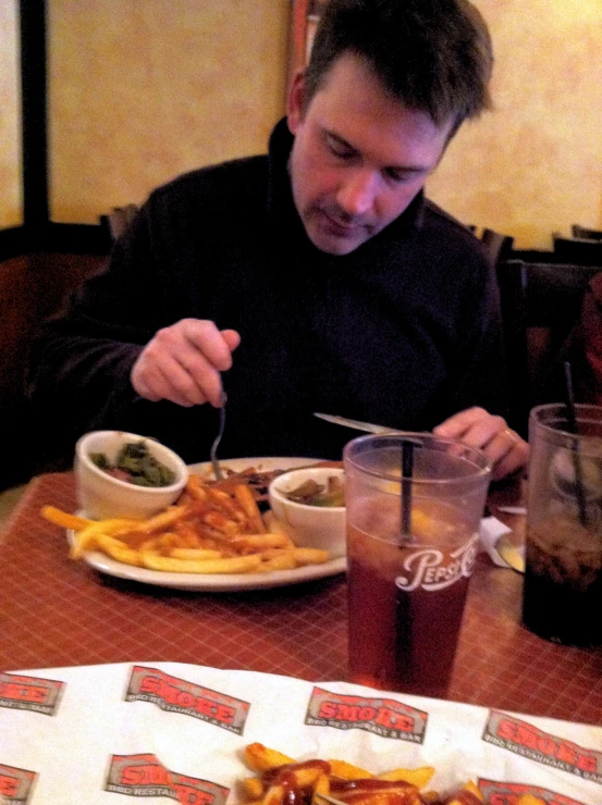 a man sitting at a table with plates and food