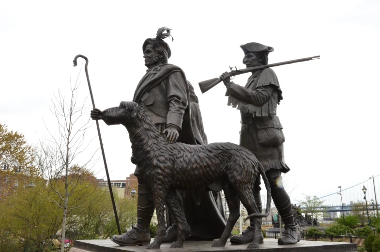 two statue of men with dogs and brooms