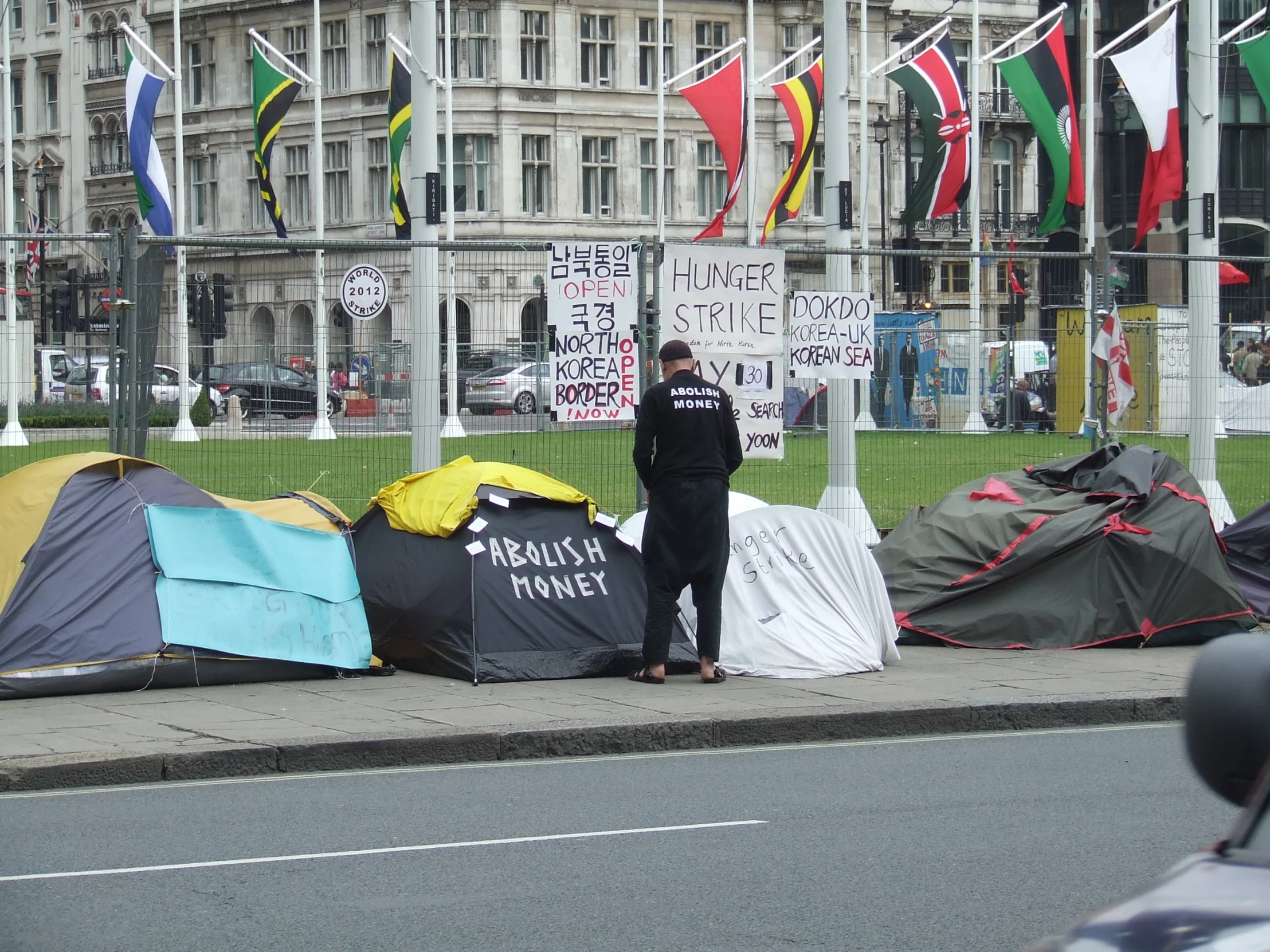 a man standing near tents sitting on the sidewalk