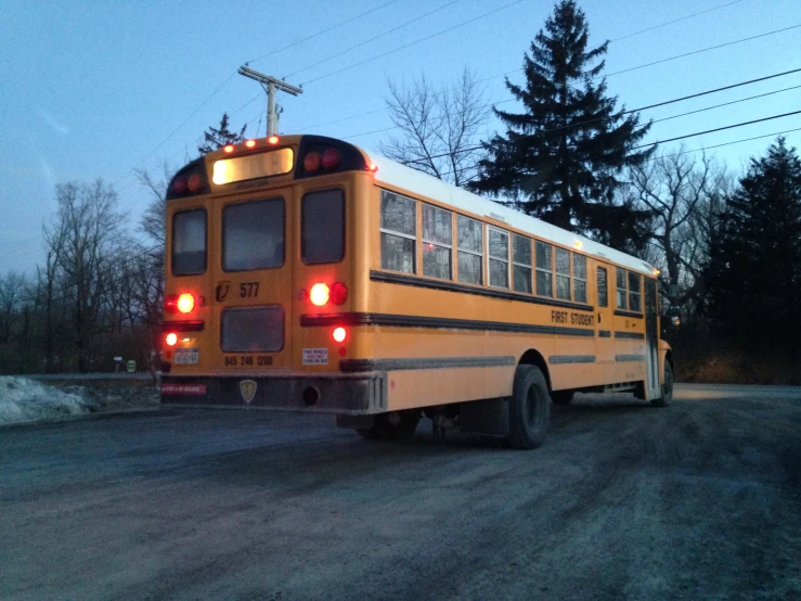 an empty school bus sits alone in a dirt lot