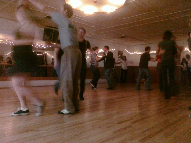 a group of people standing in a room with a few people dancing around