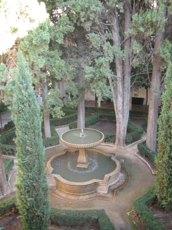 a beautiful fountain in the middle of a small plaza surrounded by trees