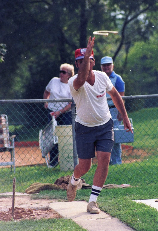 a man with a cap tossing a baseball in the air