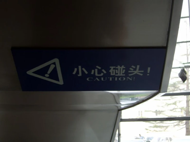 a blue and white sign reads caution in a foreign language
