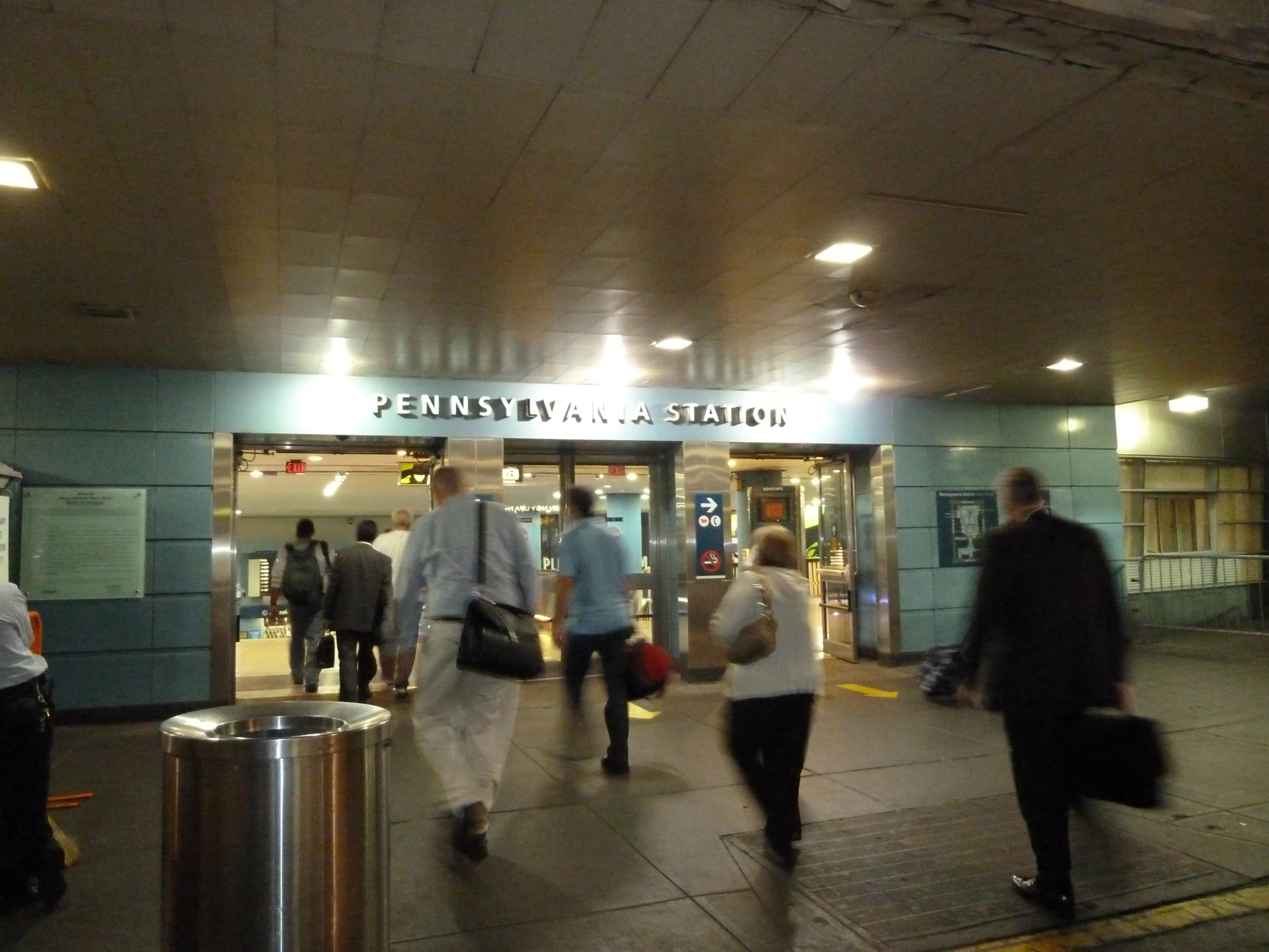 the people are walking in front of a train station