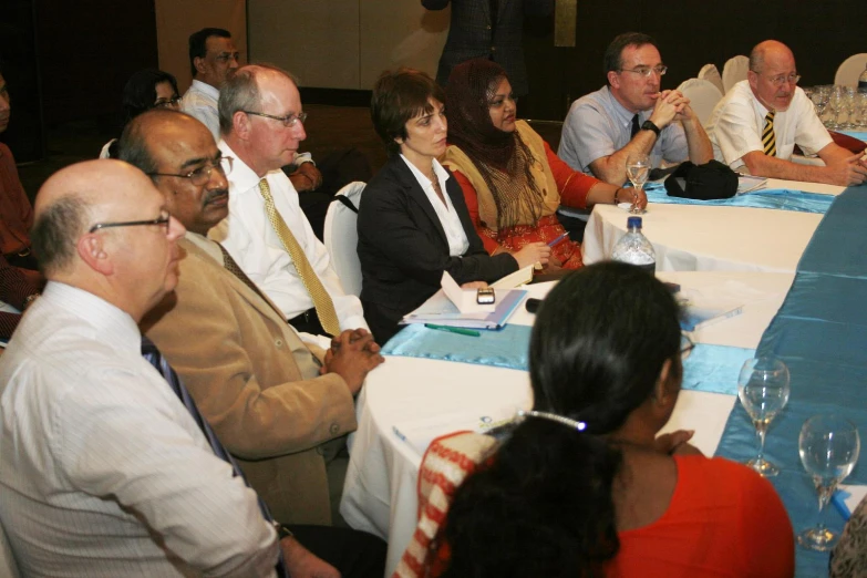 a group of people sitting at a table looking forward