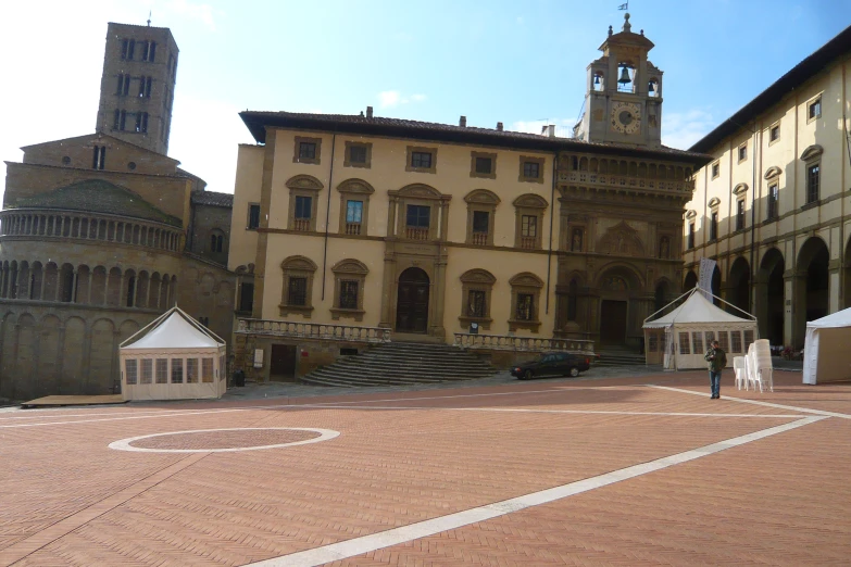 two tents line up on a city square in front of an old building