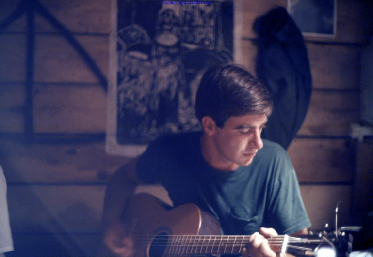 a man is playing the guitar in front of the camera