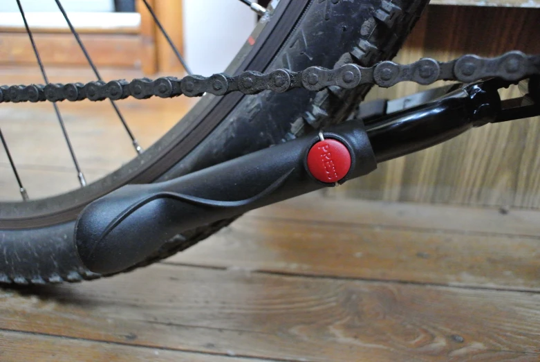 an orange and black bicycle tire near some wood