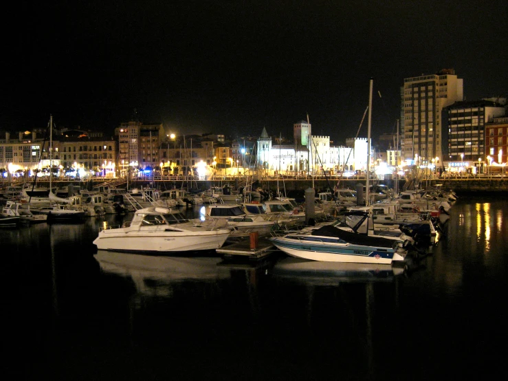a harbor filled with lots of docked boats at night