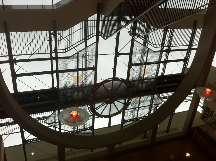 a clock is suspended in a stairwell at a train station