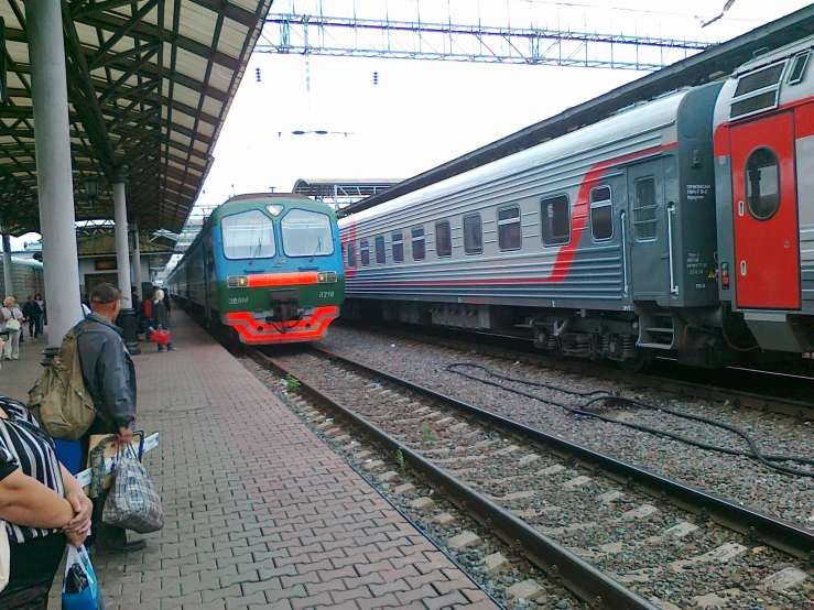 a silver train and other train cars on a track