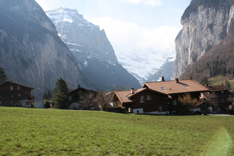 a scenic po of some houses with mountains in the background