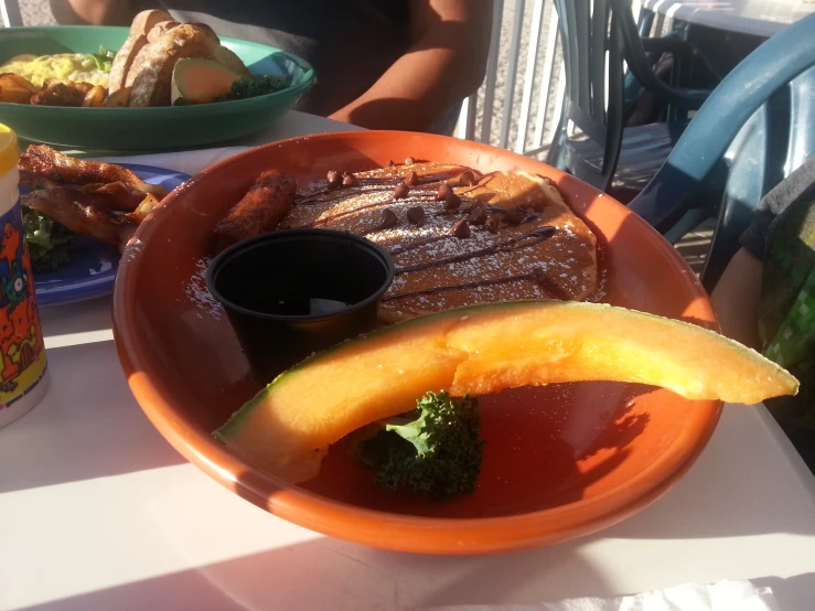 a plate of steak with broccoli, an avocado on it