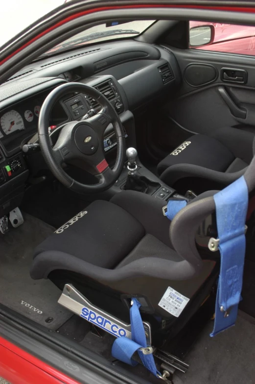 the interior of an automobile, featuring black seats and a blue dashboard tape