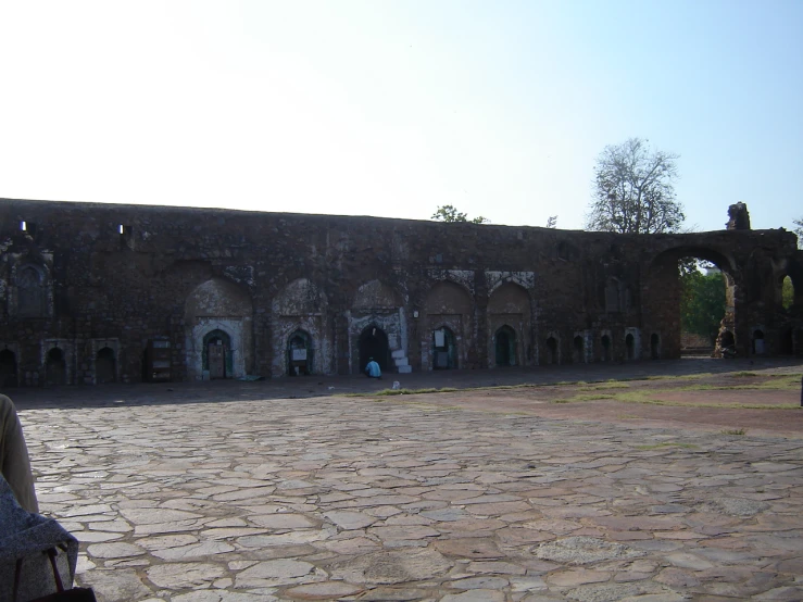 two people taking pictures in front of a large brick building