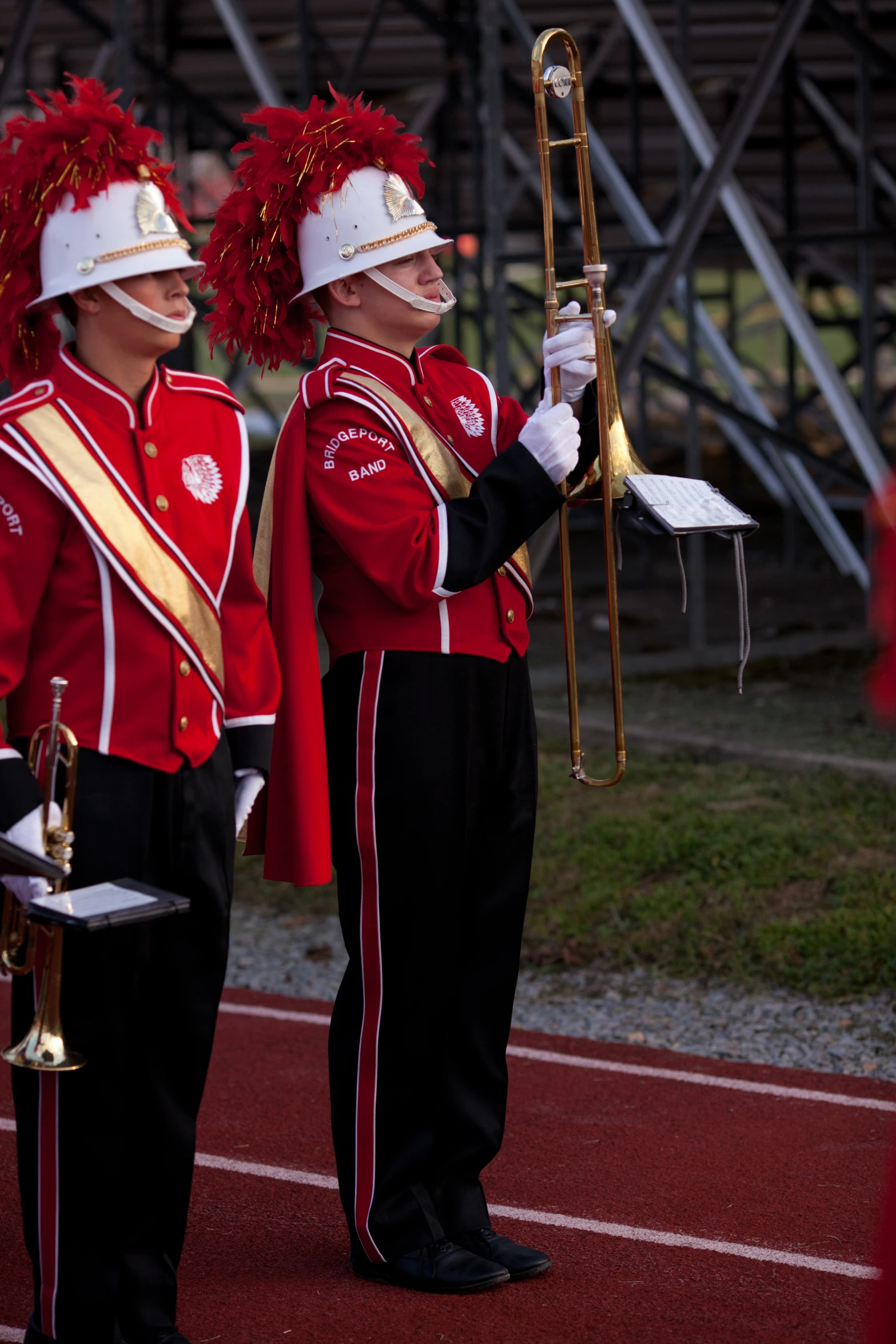 two men in uniform and their marching equipment on a track