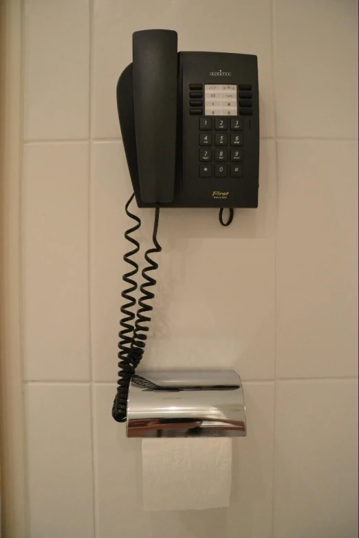 an old fashioned phone in a bathroom with a chrome plate