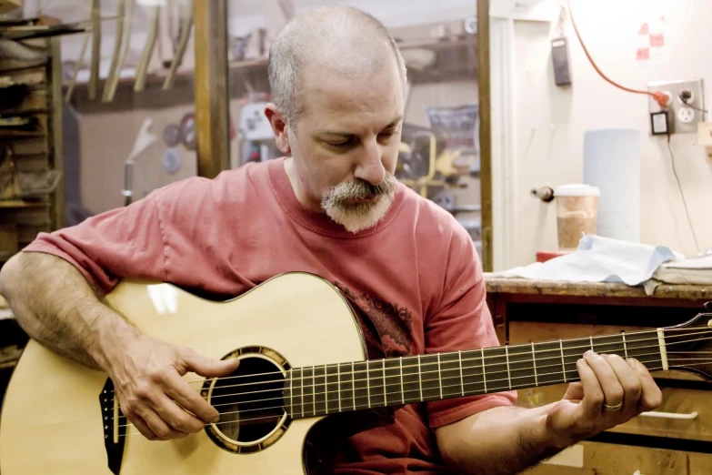 a man playing an instrument in a cluttered workshop