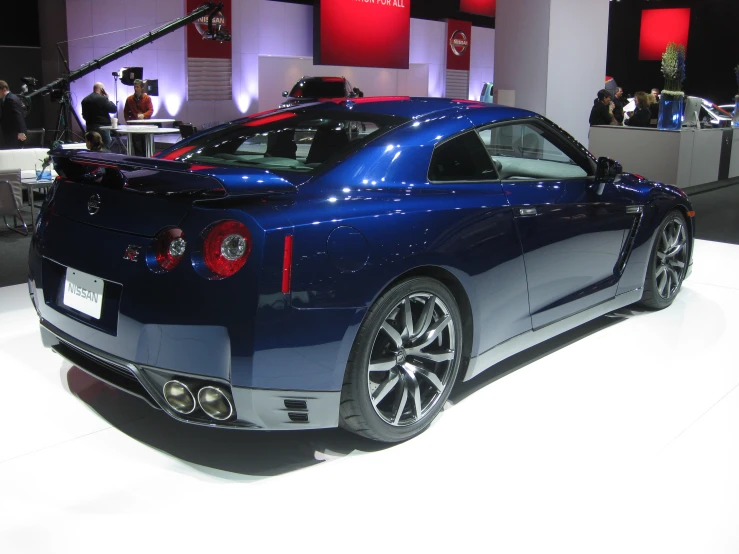 a blue sports car on display at a show