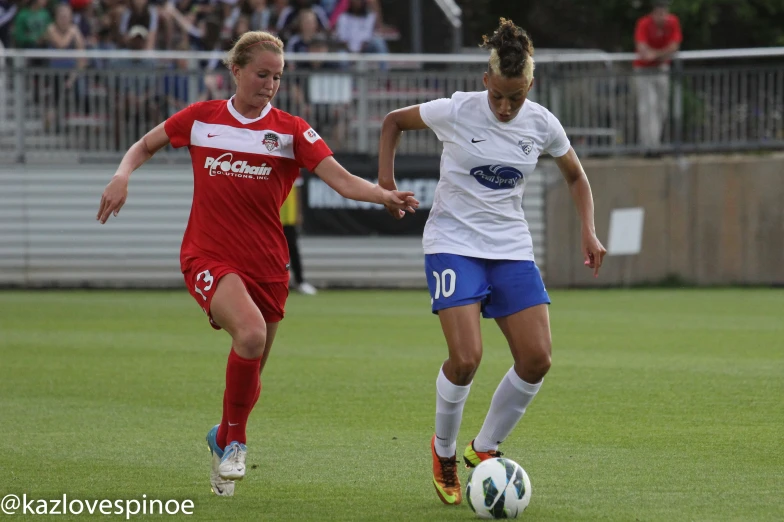 two girls playing soccer against each other during the day