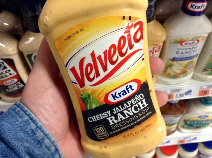 a hand holds a large yellow bottle of mayonnaise