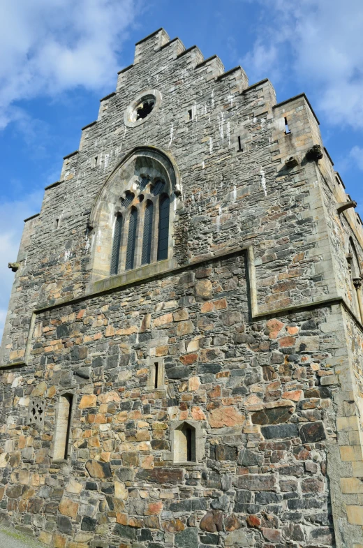 an old brick tower under a blue cloudy sky