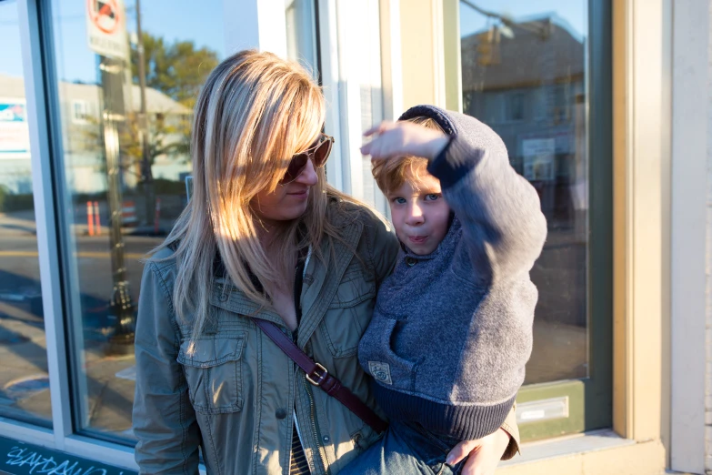 a woman with a little boy outside of a business window