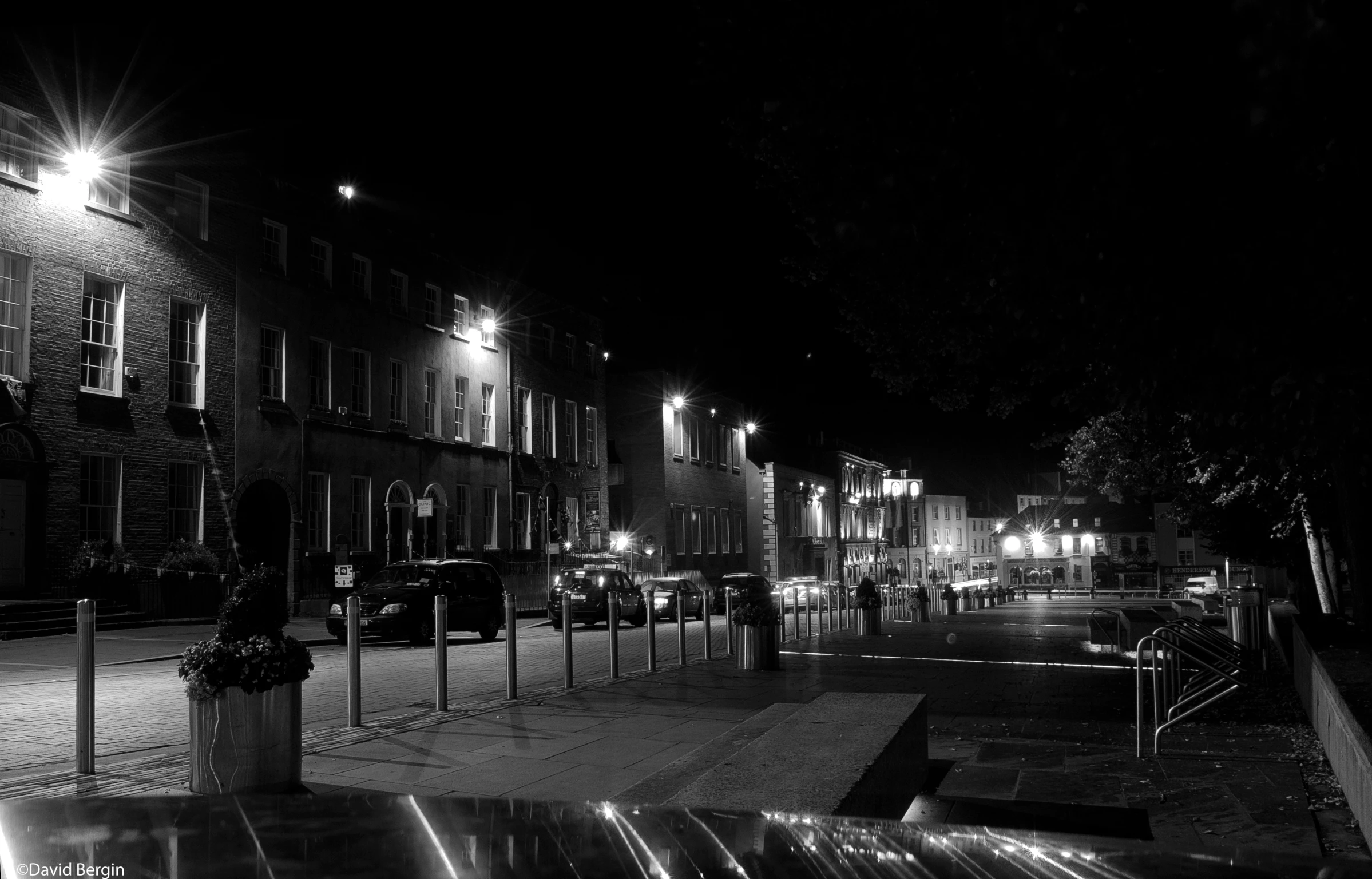 a bench and some buildings on a dark street