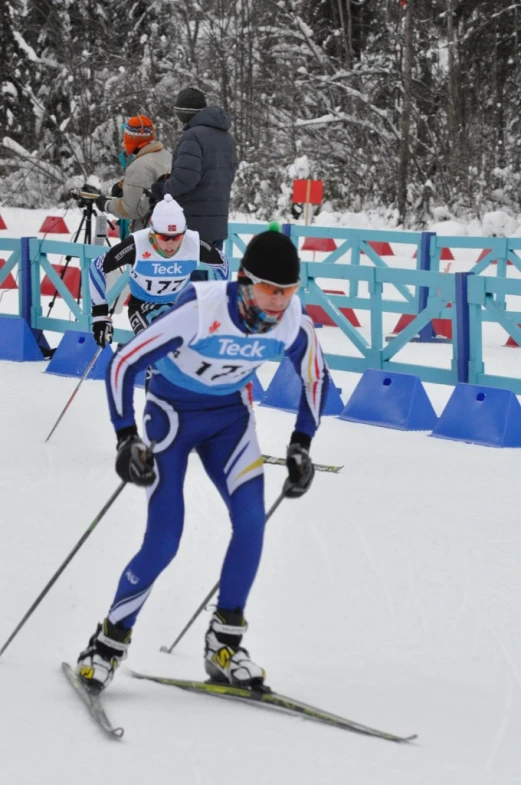 two people on skis racing down the slope