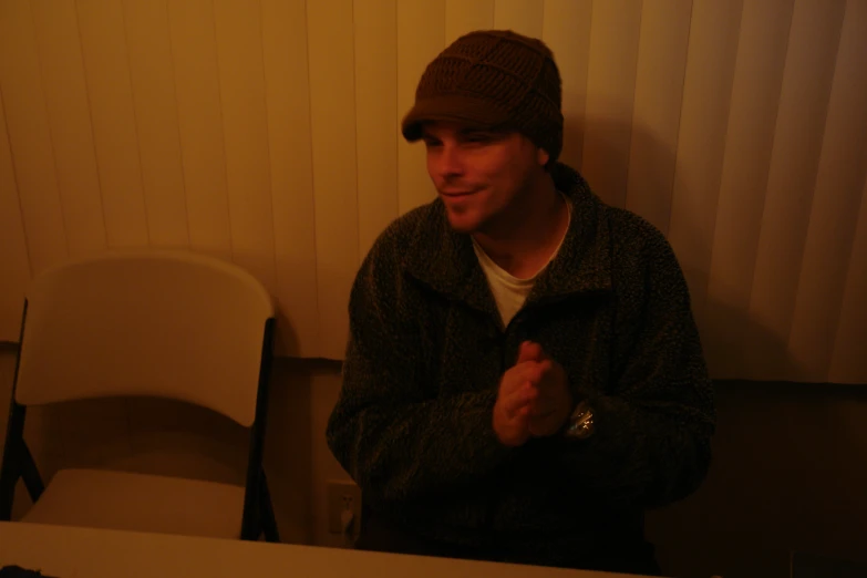 a man sits by a table in front of a white table cloth