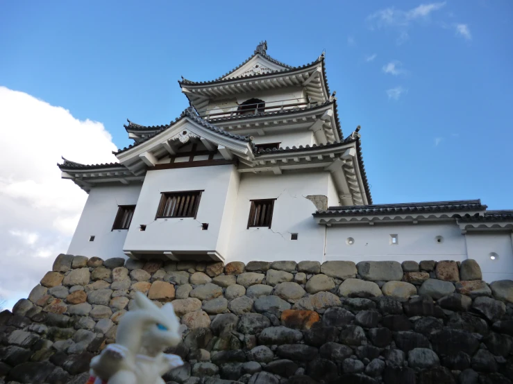 a tall white building sitting on top of a stone wall