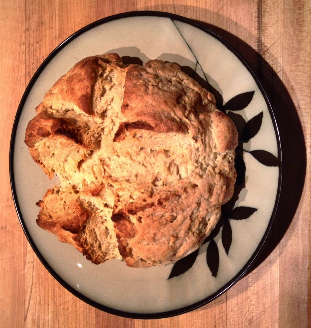 a plate on a table holding two pieces of bread