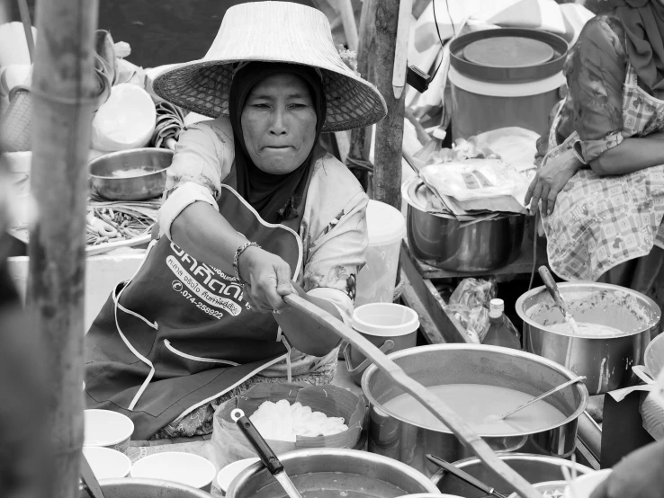 a woman cooking food on an outside grill