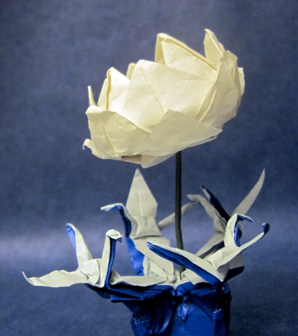 an origami flower on a blue vase