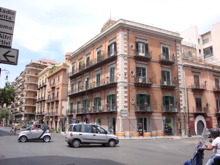 an old building with a small car driving through the street