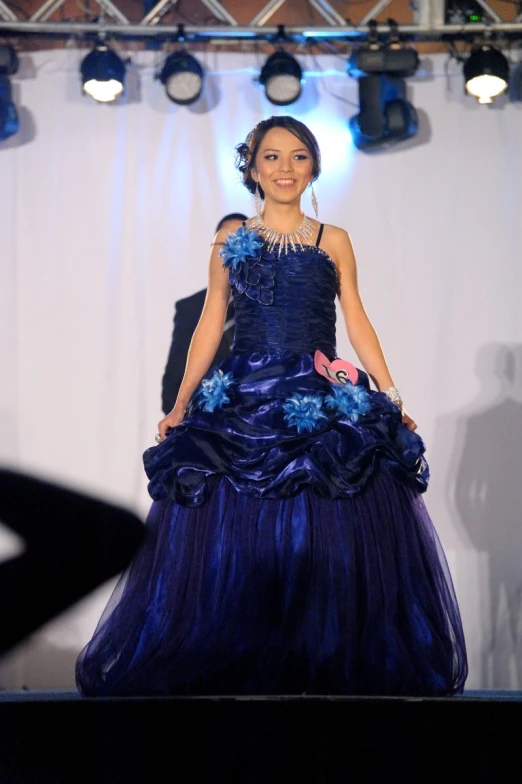 a woman on a runway wearing a blue dress