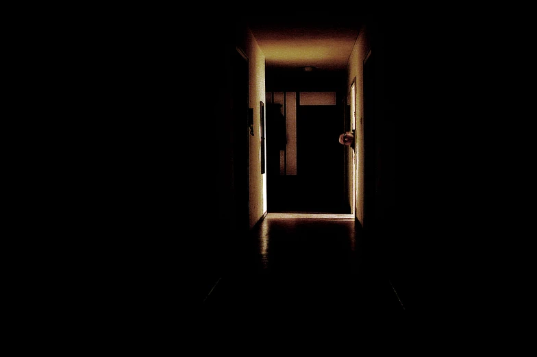 an entrance way to a long dark hallway at night