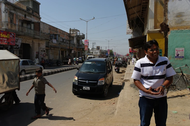 the man is walking with his child next to a small car