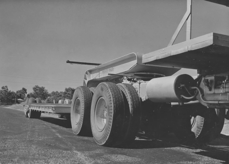 a large semi truck with big tires and flatbed in the back